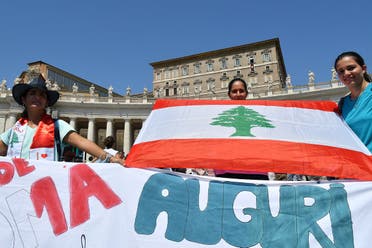 Women hold the Lebanese flag as they attends Pope Francis’ Sunday Angelus prayer from the window of the apostolic palace overlooking St.Peter’s square on August 9, 2020 at the Vatican. (AFP)