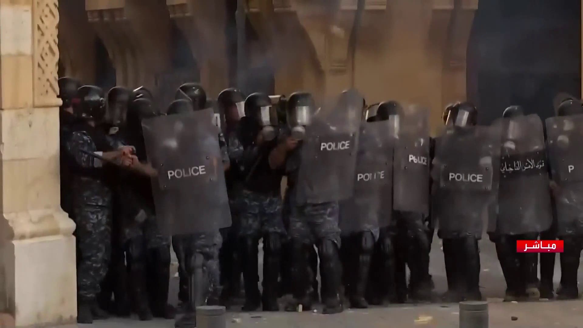 Lebanese police forces confront protesters near parliament. (Al Arabiya)