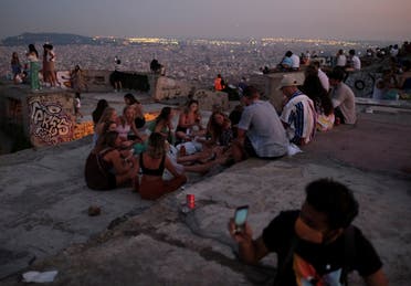 Tourists and locals gather at a lookout point, with a view of the city of Barcelona . (Reuters)