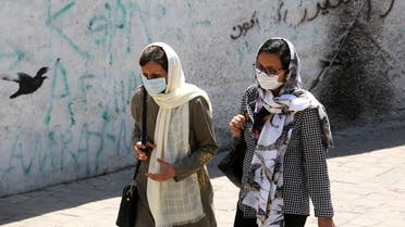 Iranian women wearing face masks walk down a street in the capital Tehran amid the novel coronavirus pandemic on August 9, 2020. 