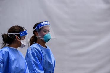 Medical staff wear personal protective equipment (PPE) kits, including facemasks and shields, as they walk near the rapid antigen coronavirus testing site at Hard Rock Stadium in Miami Gardens near Miami, on August 5, 2020. In one of two state-run locations, Hard Rock Stadium is now offering rapid testing with same-day results, with testing available for kids ages 5-17 and those 65 or older, or those who are experiencing symptoms. 1,250 free tests will be available per day at the two state-run sites.