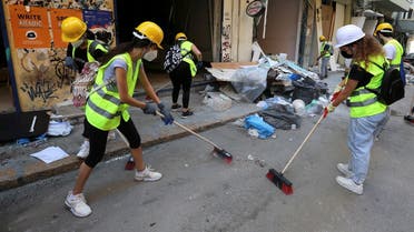 Volunteers clean debris from the street following Tuesday's blast in Beirut's port area. (Reuters)