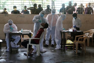 A health worker collects a swab sample from a man during a rapid antigen testing check up campaign in Mumbai. (File photo: Reuters)