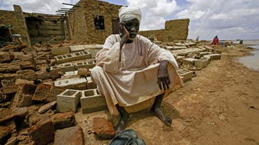 A Sudanese boy man on the rubble of a house, as a result of flooding and torrential rain, in the town of Osaylat, 50 km southeast of the capital Khartoum, on August 6, 2020,