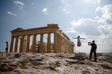 Tourists take a picture in front of the temple of the Parthenon atop the Acropolis in Athens. (Reuters)
