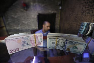 أوراق من الدولار والليرة التركية في مكتب صرافة بتركيا