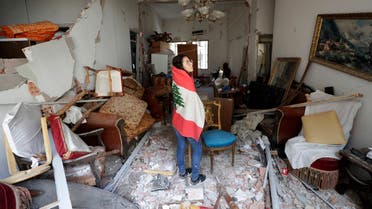 Farah Mahmoud, wrapped in Lebanese national flag, checks her parents destroyed apartment after Tuesday's explosion in the seaport of Beirut on Aug. 6, 2020. (AP)