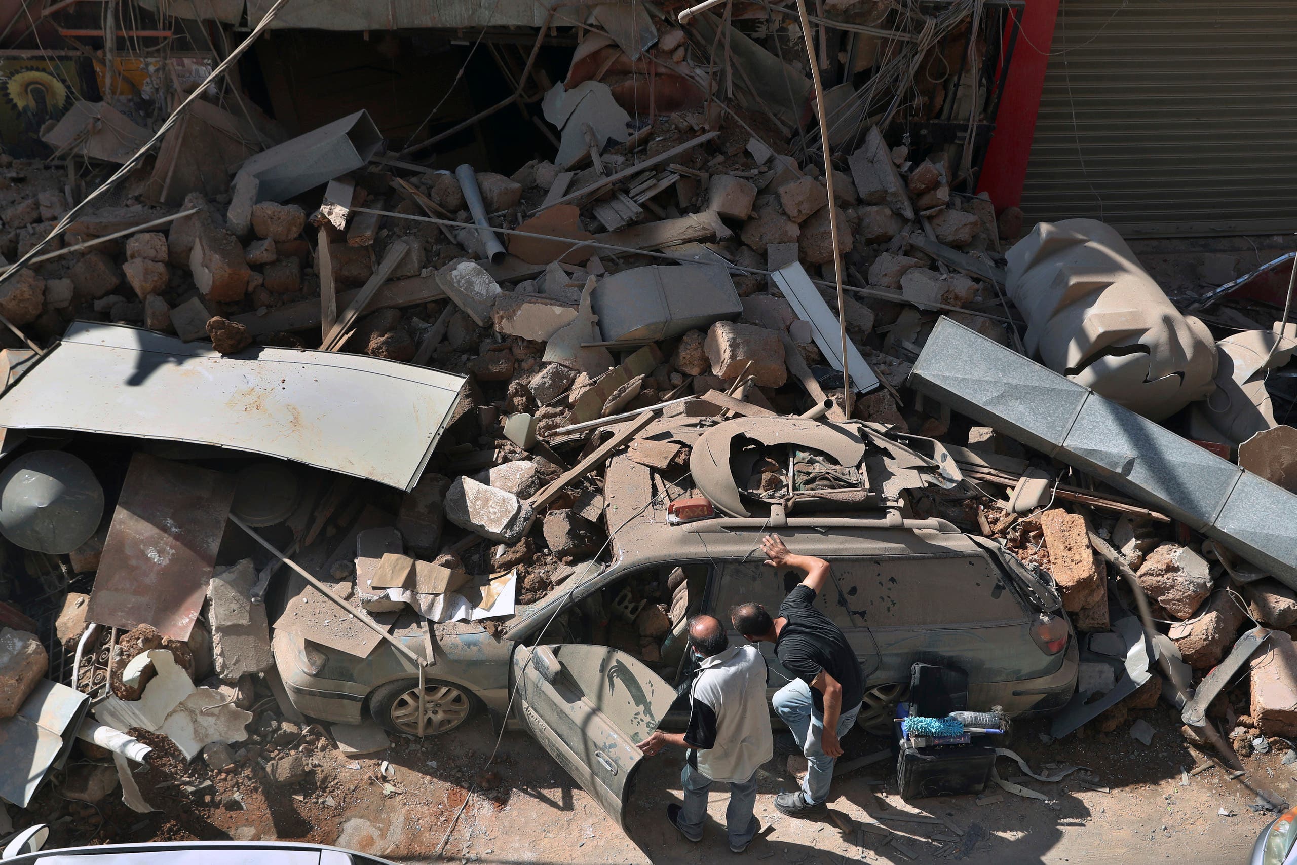 People inspect their car that was damaged in Tuesday's massive explosion in the seaport of Beirut on Aug. 5, 2020. (AP)