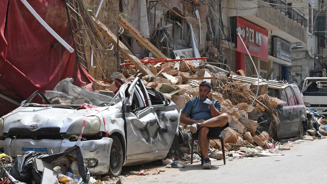 A Lebanese man talks on the phone while seated by the rubble of a destroyed traditional building in the Gemmayzeh neighbourhood, on August 12, 2020, following last week's cataclysmic port explosion which devastated the capital Beirut.