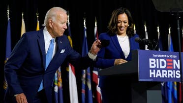 Democratic presidential candidate Joe Biden gets his face mask from the podium before his running mate Kamala Harris speaks during a campaign event, Aug. 12, 2020. (AP)