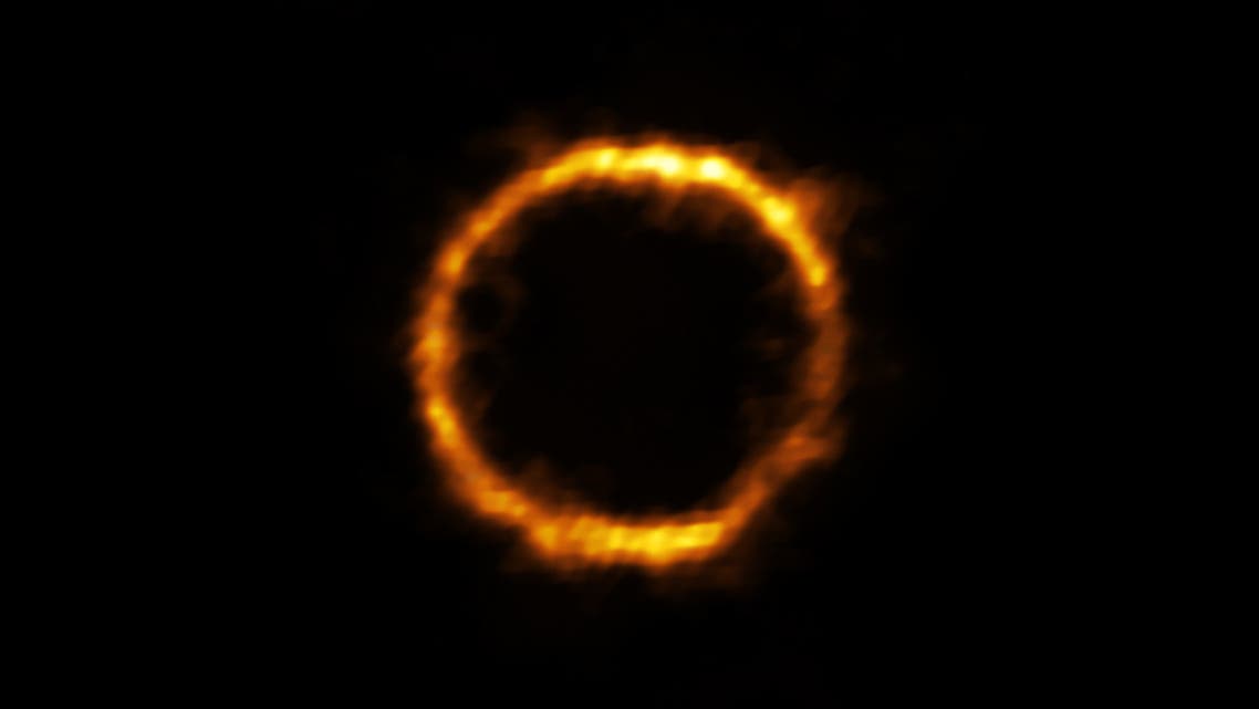This undated handout image released by The European Southern Observatory (ESO) on August 11, 2020, shows a distant galaxy named SPT0418-47 by astronomers which bears a resemblance to the Milky Way, and is gravitationally lensed by a nearby galaxy, appearing in the sky as a near-perfect ring of light. A golden halo glinting 12 billion light years away is the farthest galaxy resembling our Milky Way yet spotted, astronomers said August 12, 2020, adding the surprisingly unchaotic infant star system challenges our understanding of the early years of the Universe.