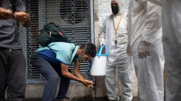 Members of the Another Approach non-governmental organization teach residents how to correctly wash their hands amid the new coronavirus pandemic, on a street in Caracas, Venezuela, Tuesday, July 21, 2020. (AP)