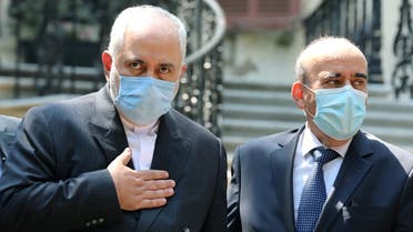 Iran's Foreign Minister Mohammad Javad Zarif and Lebanon's caretaker Foreign Minister Charbel Wehbe wear protective face masks as they stand at the Ministry of Foreign Affairs in Beirut. (Reuters)