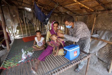 A health worker gives a polio vaccine to a child at a slum area in Lahore, Pakistan, Saturday, Aug. 15, 2020. (AP)