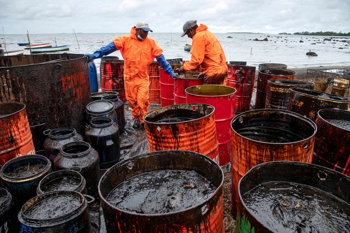 Workers collect leaked oil at the beach in Riviere des Creoles on August 15, 2020, due to the oil leaked from vessel MV Wakashio off the coast of south-east Mauritius. (AFP)