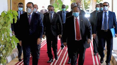 A handout picture released by the Egypt’s PM’s official Facebook page on August 15, 2020 shows the mask-clad Madbouli (L) with Sudan’s Hamdok (C-R) at the capital’s Khartoum International Airport.  (Egyptian Prime Minister’s Office / AFP)
