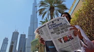 A man reads a copy of UAE-based The National newspaper near the Burj Khalifa, the tallest structure and building in the A man reads a copy of UAE-based The National newspaper near the Burj Khalifa in the gulf emirate of Dubai. (AFP)irate of Dubai