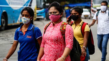 People wearing face masks walk to catch buses in Kolkata, India on Aug. 14, 2020. (AP)
