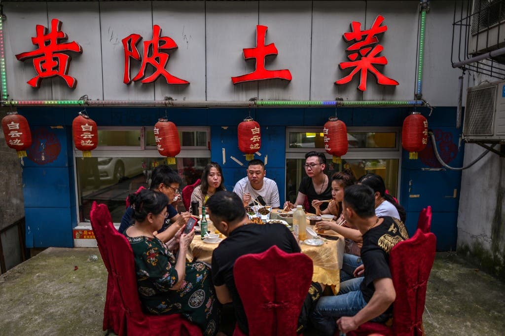 A group of people eat next to a restaurant in Wuhan, China's central Hubei province on May 27, 2020. (File photo: AFP)