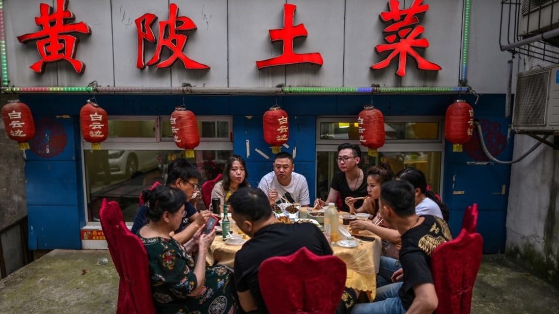 A group of people eat next to a restaurant in Wuhan, China's central Hubei province on May 27, 2020. (File photo: AFP)