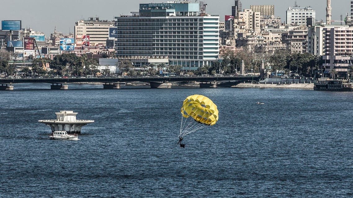 A man parasails in the Nile river during a training session in the Egyptian capital Cairo, on January 26, 2020, with the buildings overlooking the central Tahrir Square seen in the background. (AFP)