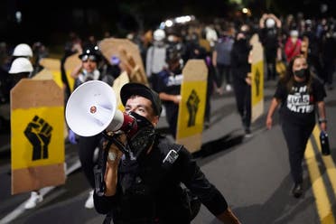 A protester leads a crowd of demonstrators toward the Multnomah County Sheriff’s Office on Friday, Aug. 7, 2020 in Portland, Oregon. (AP)