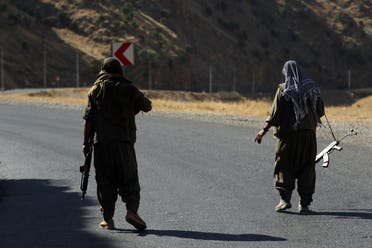 Members of the Kurdistan Workers' Party (PKK) carry automatic rifles on a road in the Qandil Mountains, the PKK headquarters in northern Iraq, on June 22, 2018. (AFP)