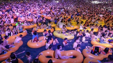 A photo shows people watching a performance as they cool off in a swimming pool in Wuhan in China. (AFP)