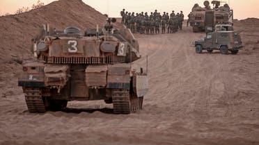 Israeli infantry soldiers gather next to tanks and an armoured personnel carrier near the Israeli border with the Gaza Strip, on August 16, 2020. (AFP)