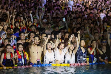 A photo shows people watching a performance as they cool off in a swimming pool in Wuhan in China. (AFP)