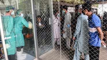 In this picture taken on July 23, 2020, people wait their turn to take a COVID-19 coronavirus test at a testing point in Karachi. (AFP)
