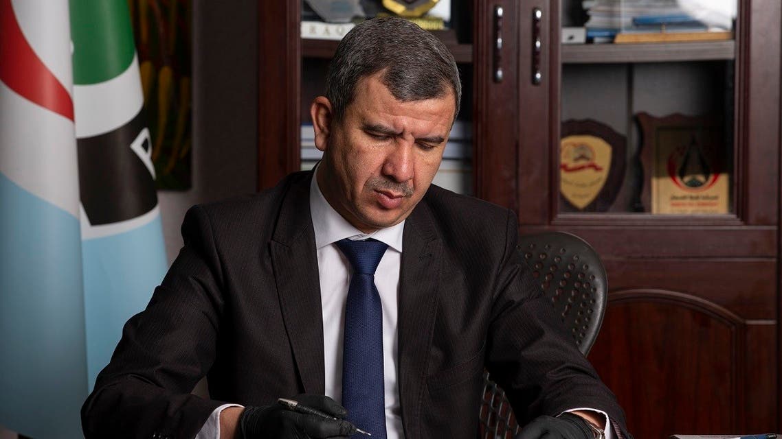 Iraqi Minister of Oil Ihsan Abdul Jabbar reads documents at the Basra Oil Company in Iraq's southern port city, on May 9, 2020. (AFP)