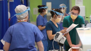 In this photo taken on Monday, May 4, 2020, medical staff wearing face masks and shields to protect against coronaviurs, work in the respiratory emergency department at Craigavon Area Hospital in Co Armagh, Northern Ireland. (AP)
