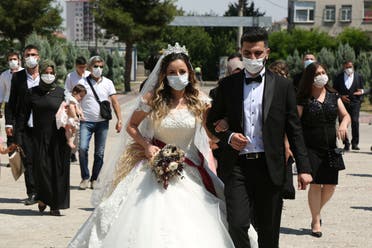 Bride Pelsin Akkoyun and groom Nizamettin Bingol, wearing protective face masks, walk following their civil wedding ceremony, amid the spread of the coronavirus disease (COVID-19), in Diyarbakir, Turkey, July 2, 2020. Turkey reopened its wedding halls in one of the final steps of reopening from the shutdown due to the coronavirus disease (COVID-19). (File photo: Reuters)