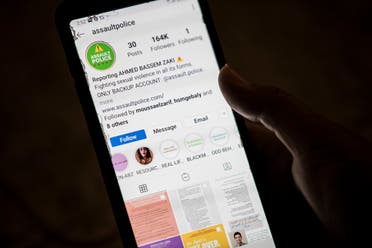 A woman checks on her phone an Instagram account for reporting allegations of sexual harassment and misconduct against Ahmed Bassam Zaki, a 22-year-old student, in Cairo on July 15, 2020. (AFP)