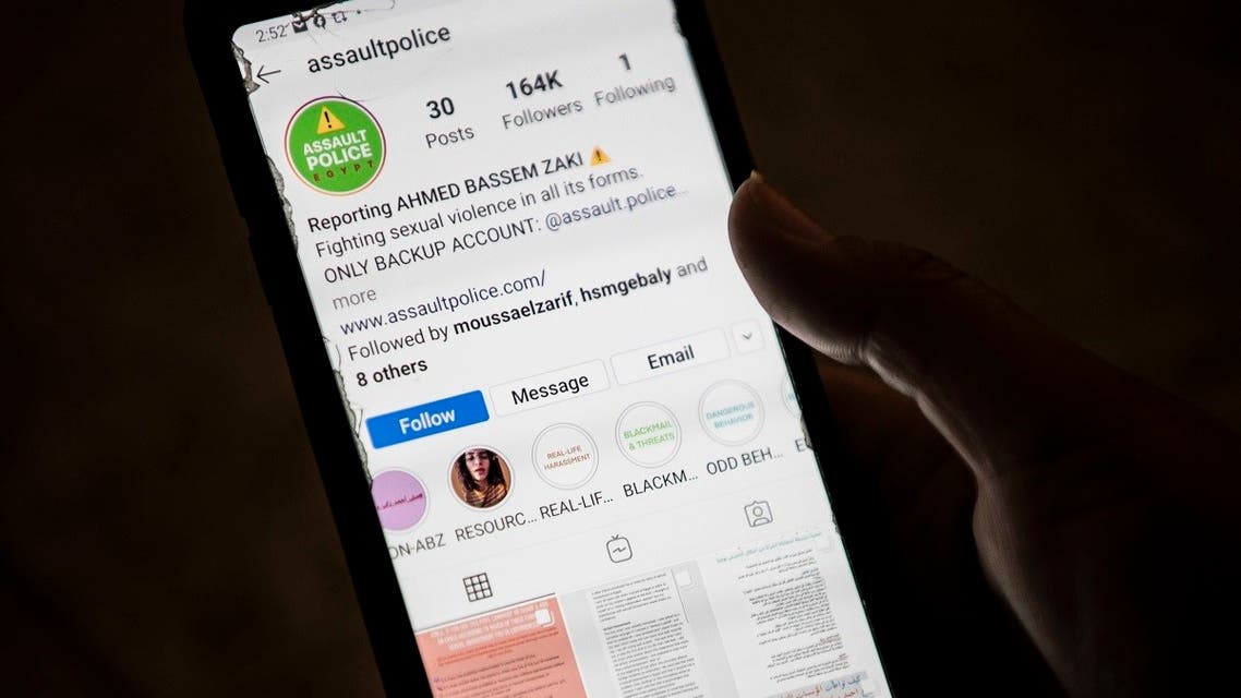 A woman checks on her phone an Instagram account for reporting allegations of sexual harassment and misconduct against Ahmed Bassam Zaki, a 22-year-old student, in Cairo on July 15, 2020. (AFP)