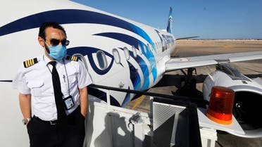 A flight attendant wearing a protective face mask stands at the entrance of a plane at Sharm el-Sheikh International Airport. (Reuters)