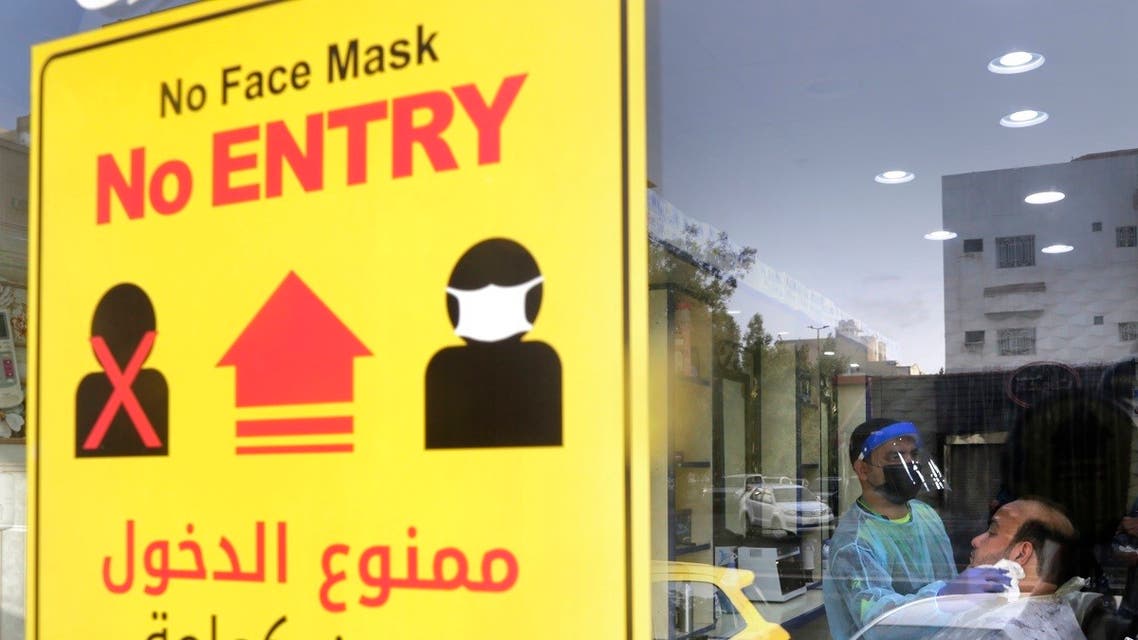 A poster showing healthy procedures to help curb the spread of the coronavirus, hangs at a barber shop window in Jeddah, Saudi Arabia. (AFP)