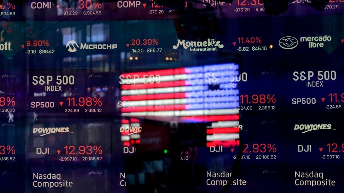 A United States flag is reflected in the window of the Nasdaq studio, which displays indices and stocks down, in Times Square, New York, Monday, March 16, 2020. (AP)