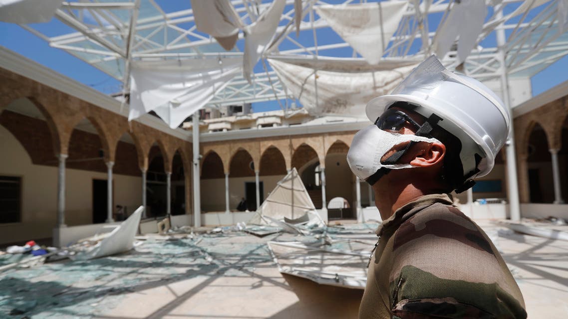 A French soldier looks at his comrades removing the debris of a school playground roof that was destroyed by Aug. 4 explosion that hit the seaport of Beirut on Aug. 20, 2020. (AP)