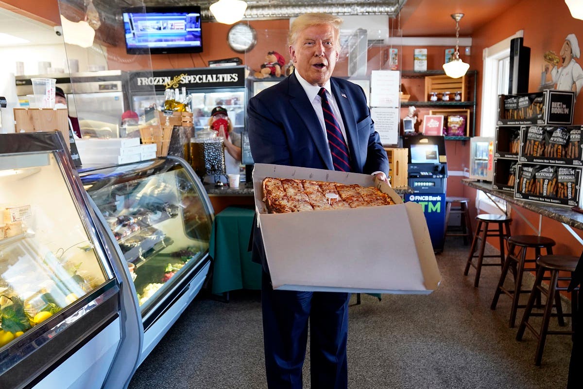 US President Donald Trump holds a pizza after speaking at a campaign event, Aug. 20, 2020, in Pennsylvania. (AP)