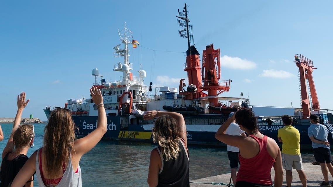 People wave as the Sea-Watch 4 rescue ship sets sails from the port of Burriana on August 15, 2020, where she has been carrying maintenance operations before leaving on her new mission. (AFP)