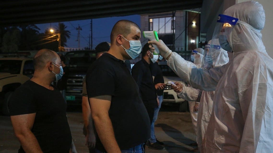 Iraqi Shia Muslim men get their temperature checked as they arrive to participate in Ashura commemorations at the headquarters of the head of Hikma party Ammar al-Hakim, in Baghdad, August 21, 2020. (AFP)