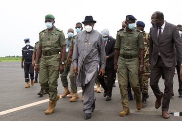 Former Nigerian President Goodluck Jonathan (2L) walks at the International Airport in Bamako upon his arrival on August 22, 2020 next to by Malick Diaw (L), the Vice President of the CNSP. (AFP)