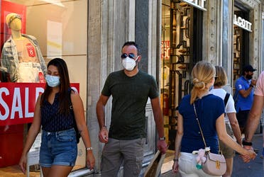 People wearing a face mask walk along the Via del Corso main shopping street on August 20, 2020 in Rome. (AFP)