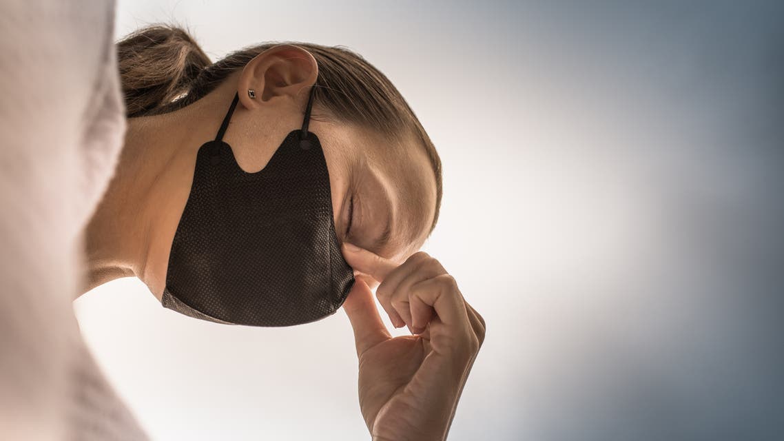 Closeup of tired stressed woman wearing face mask. Coronavirus concept. stock photo