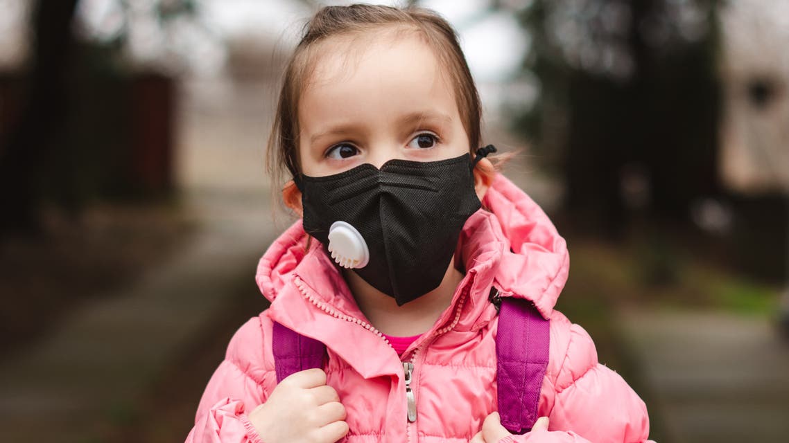 Little girl wearing pollution mask. stock photo