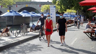 Pedestrians wearing protective face masks walk along the Seine river banks, Paris, France, August 15, 2020. (Reuters)