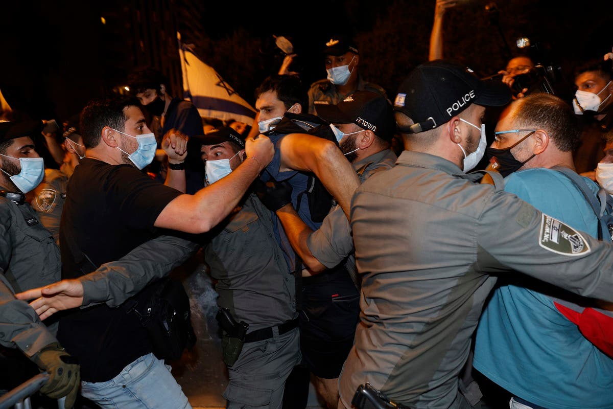Israeli policemen remove protesters from the street during a demonstration of thousands against the Israeli government near the PM Netanyahu's residence in Jerusalem, August 22, 2020. (AFP)