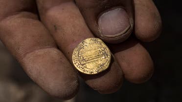 Israeli archaeologist Shahar Krispin displays a gold coin that was discovered at an archeological site in central Israel, Tuesday, Aug 18, 2020. (AP)